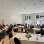 Ein Raum voller Personen an Tischen